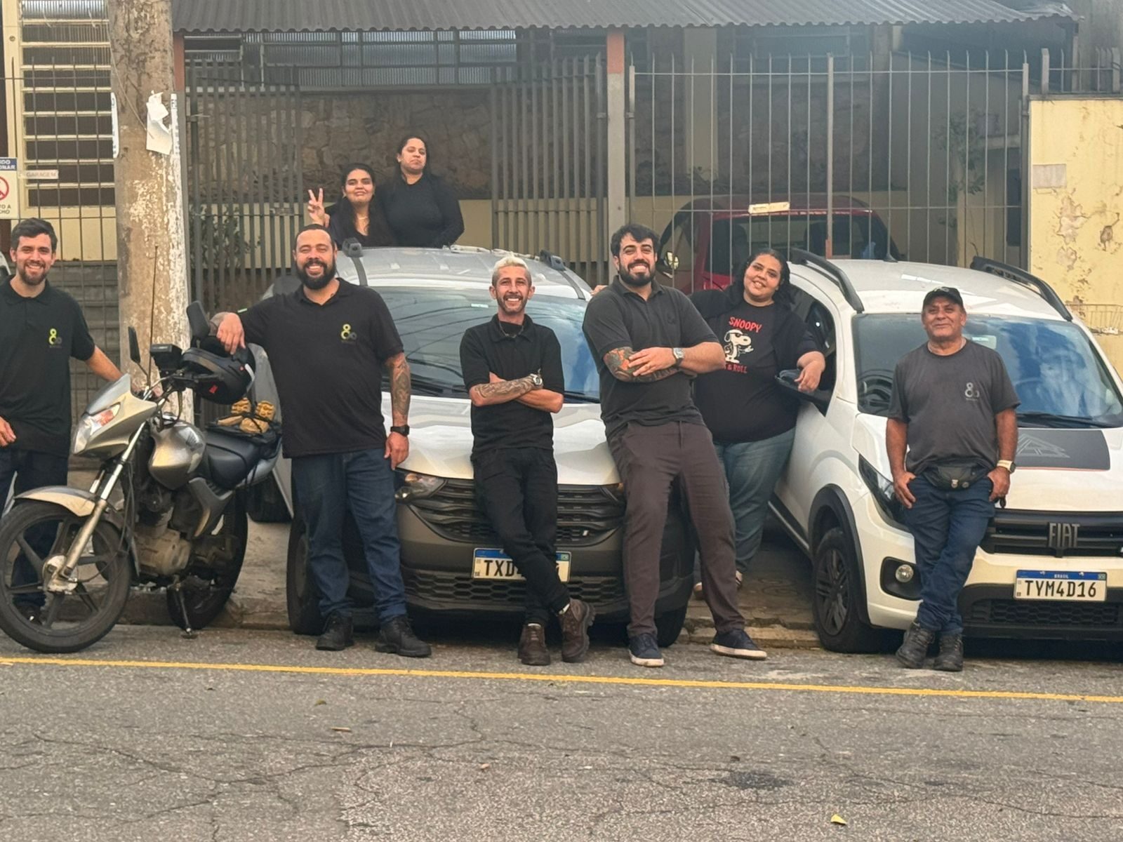 Técnicos e equipe administrativa da Eco Lift Elevadores com a frota de atendimento